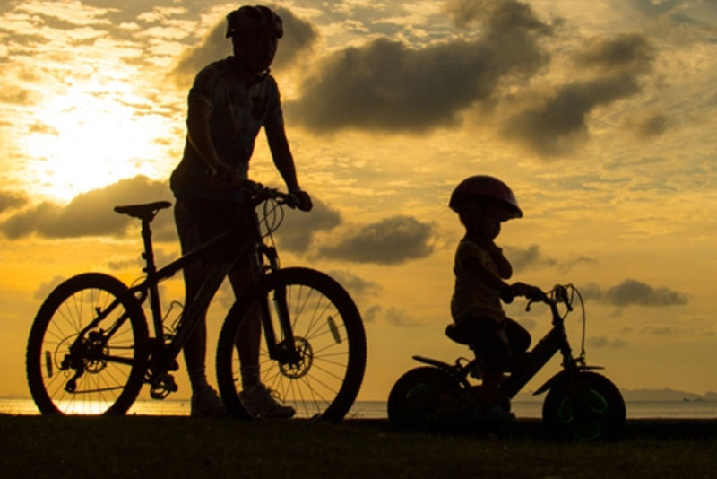 an adult and a child riding bicycles