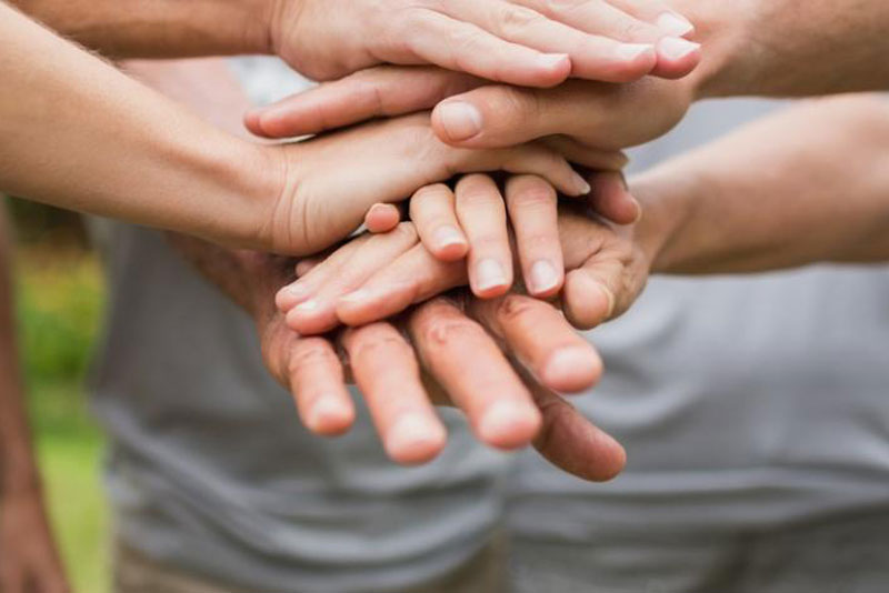 A group of people putting their hands together.