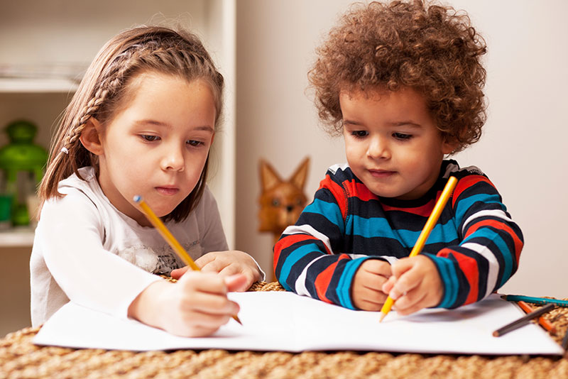a little boy and girl are drawing