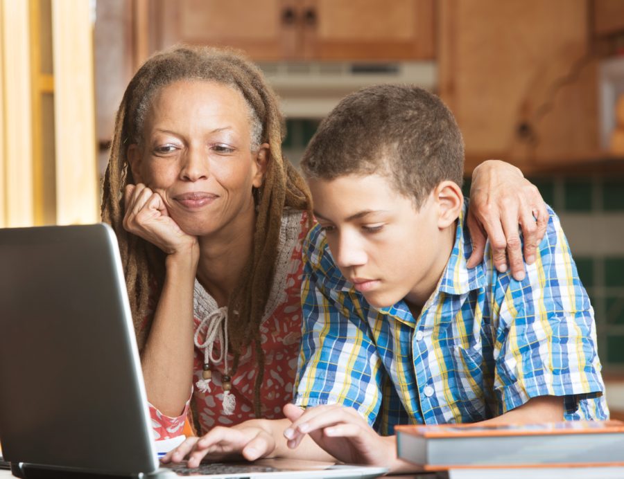 A woman and a boy looking at a laptop.
