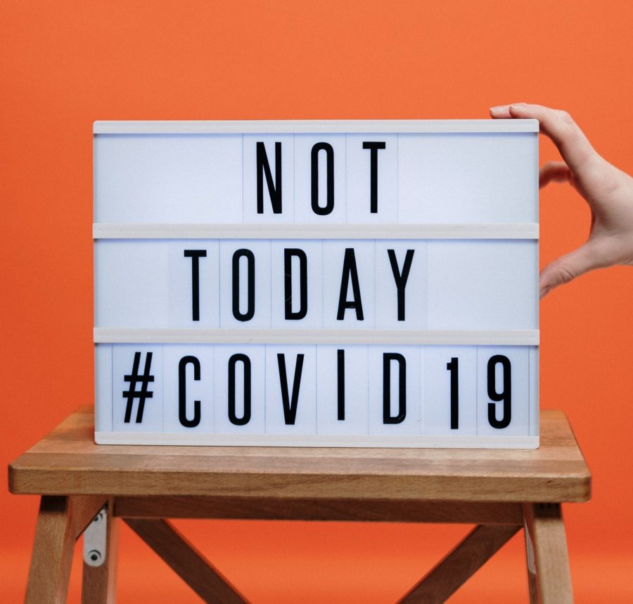 A person holding up a sign that says not today covid19.
