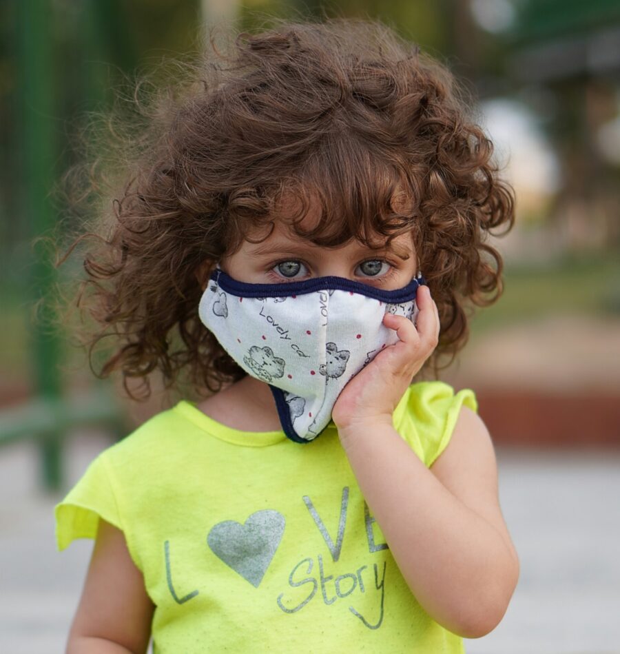 a cute little girl wearing a face mask